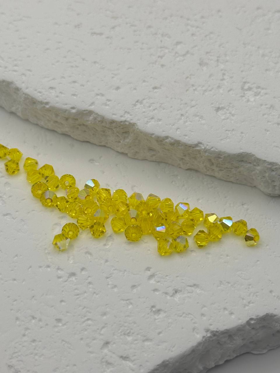 Yellow beads scattered on a textured white surface