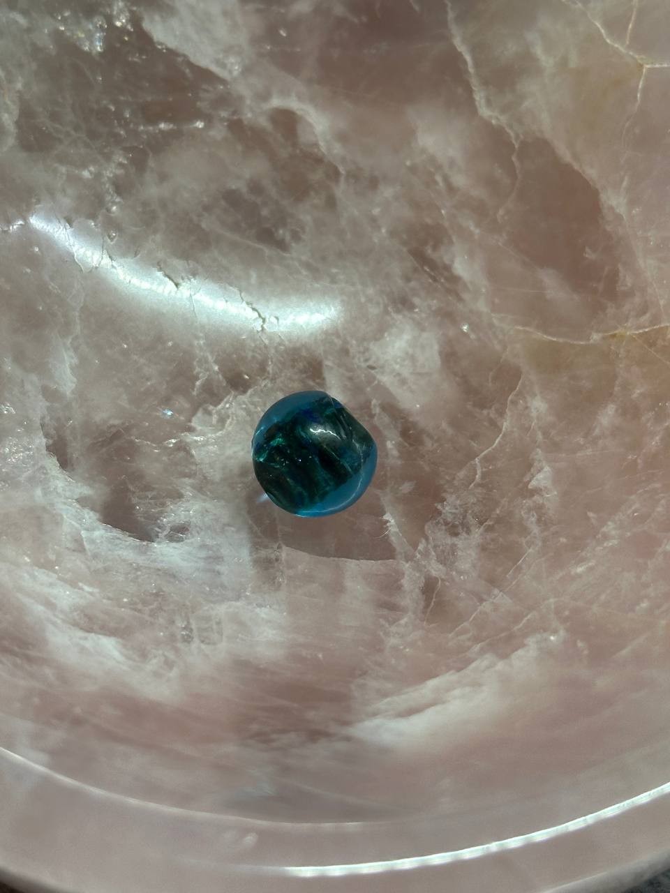 Blue marble on a textured pink surface