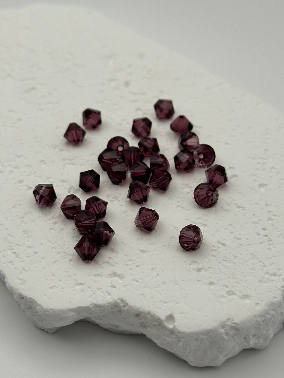 Purple beads on a textured white surface