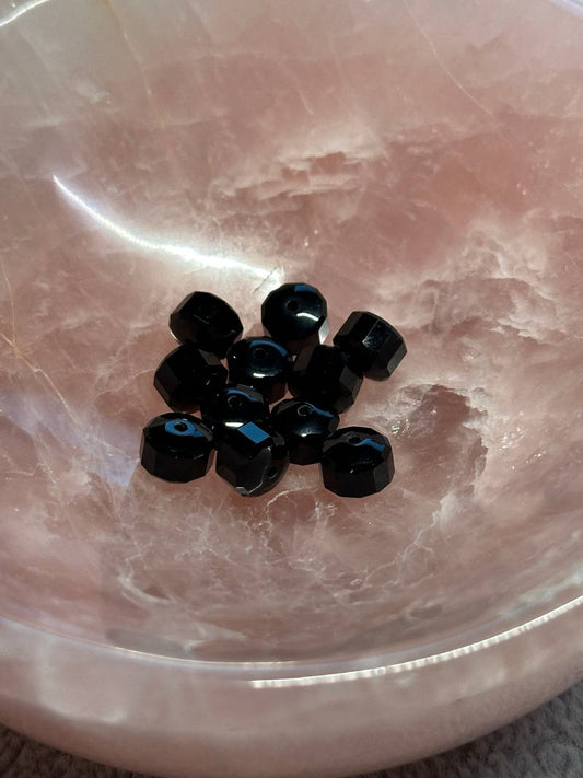 Black beads on a pink marble surface