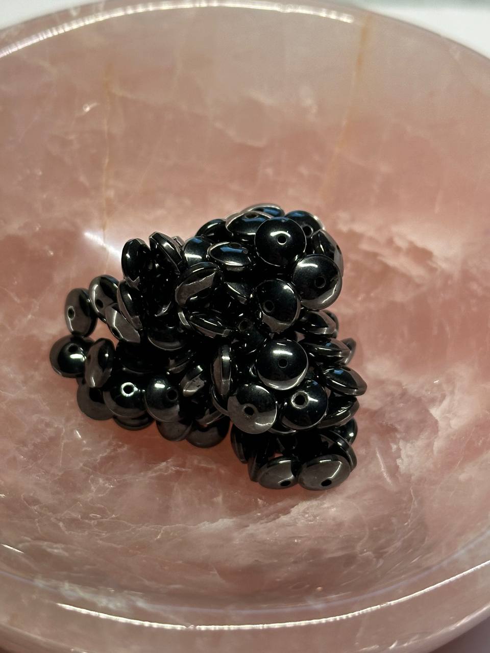 Black hemalyke beads on a pinkish-brown surface