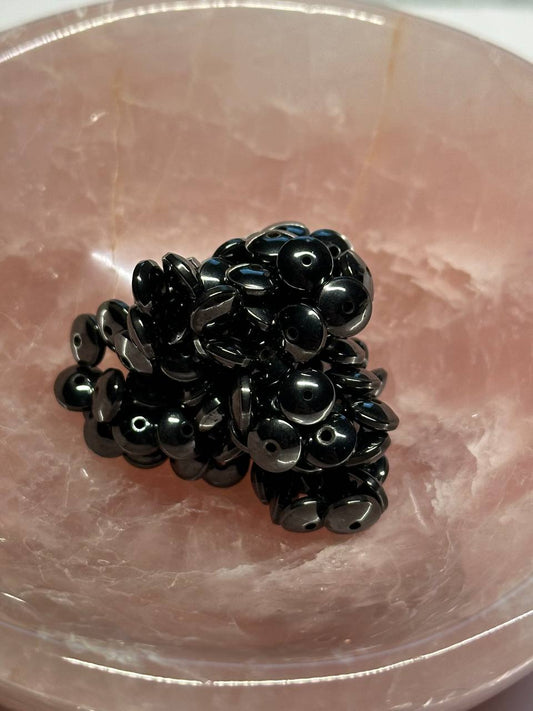 Black hemalyke beads on a pinkish-brown surface