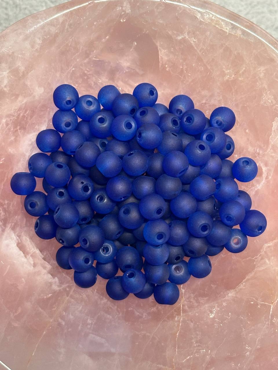 Blue beads on a pinkish surface