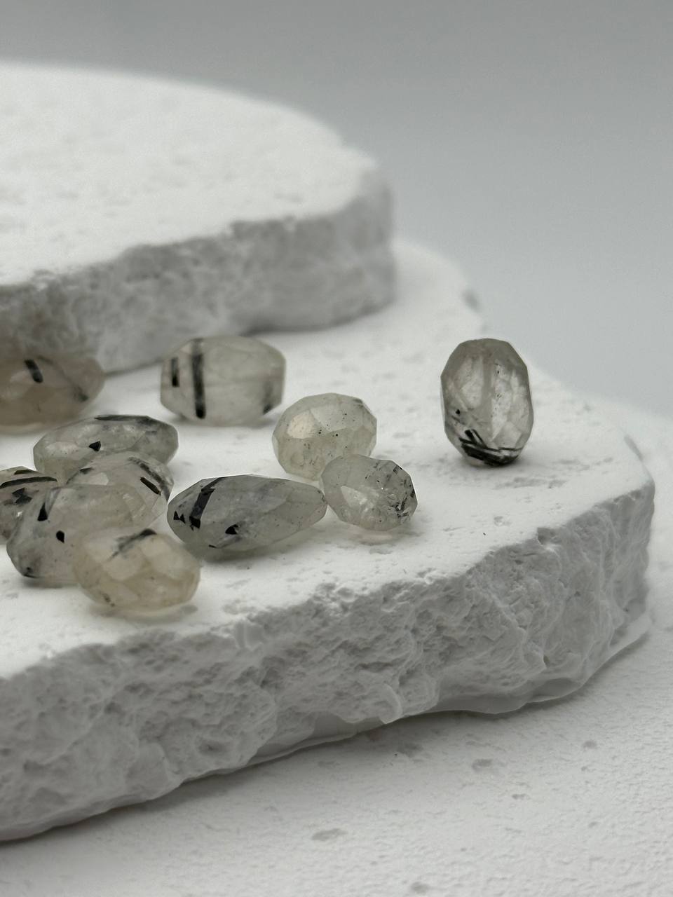 Tourmalinated quartz beads on white surface