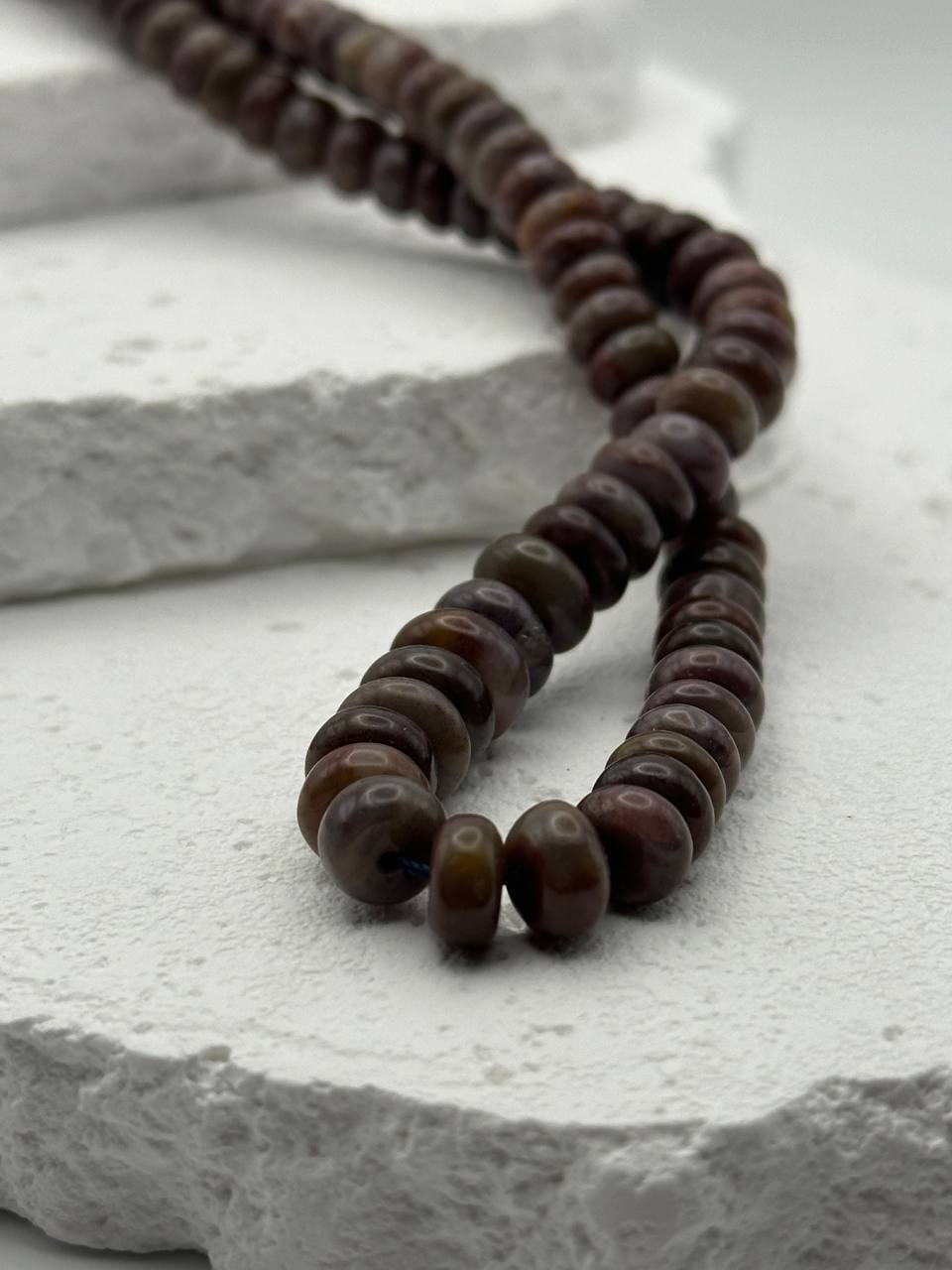 Brown beads on a textured stone surface