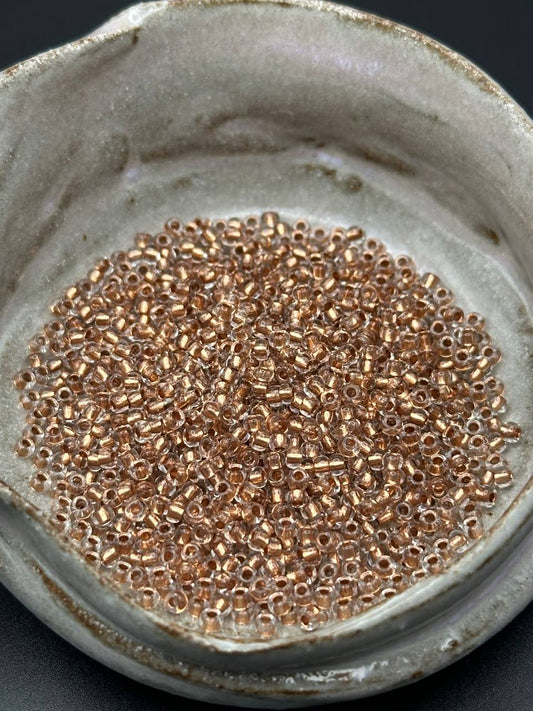 small container filled with copper lined beads