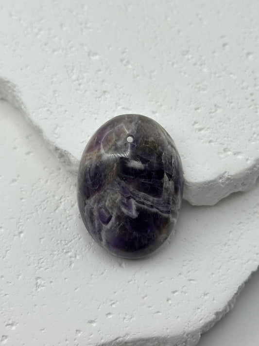 Amethyst crystal on a white stone surface