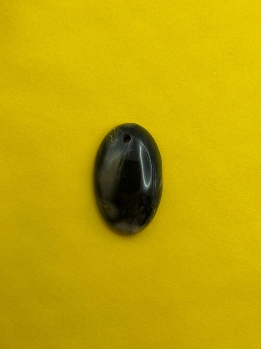 Black oval stone on a yellow background