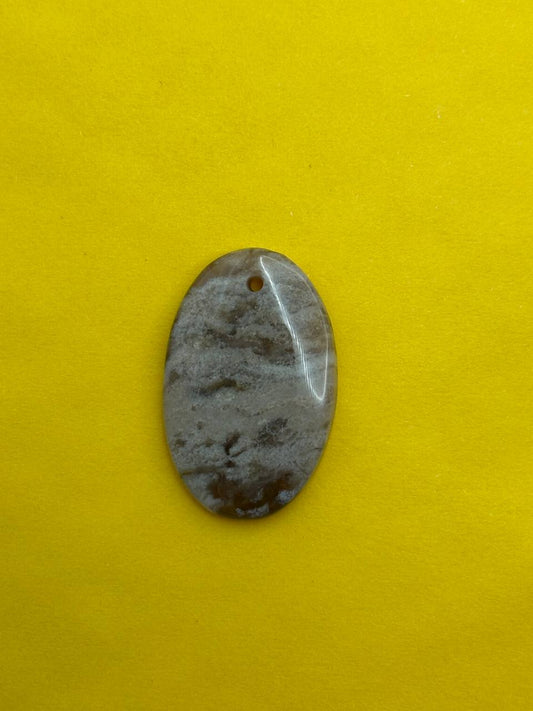 Oval-shaped stone pendant on a yellow background