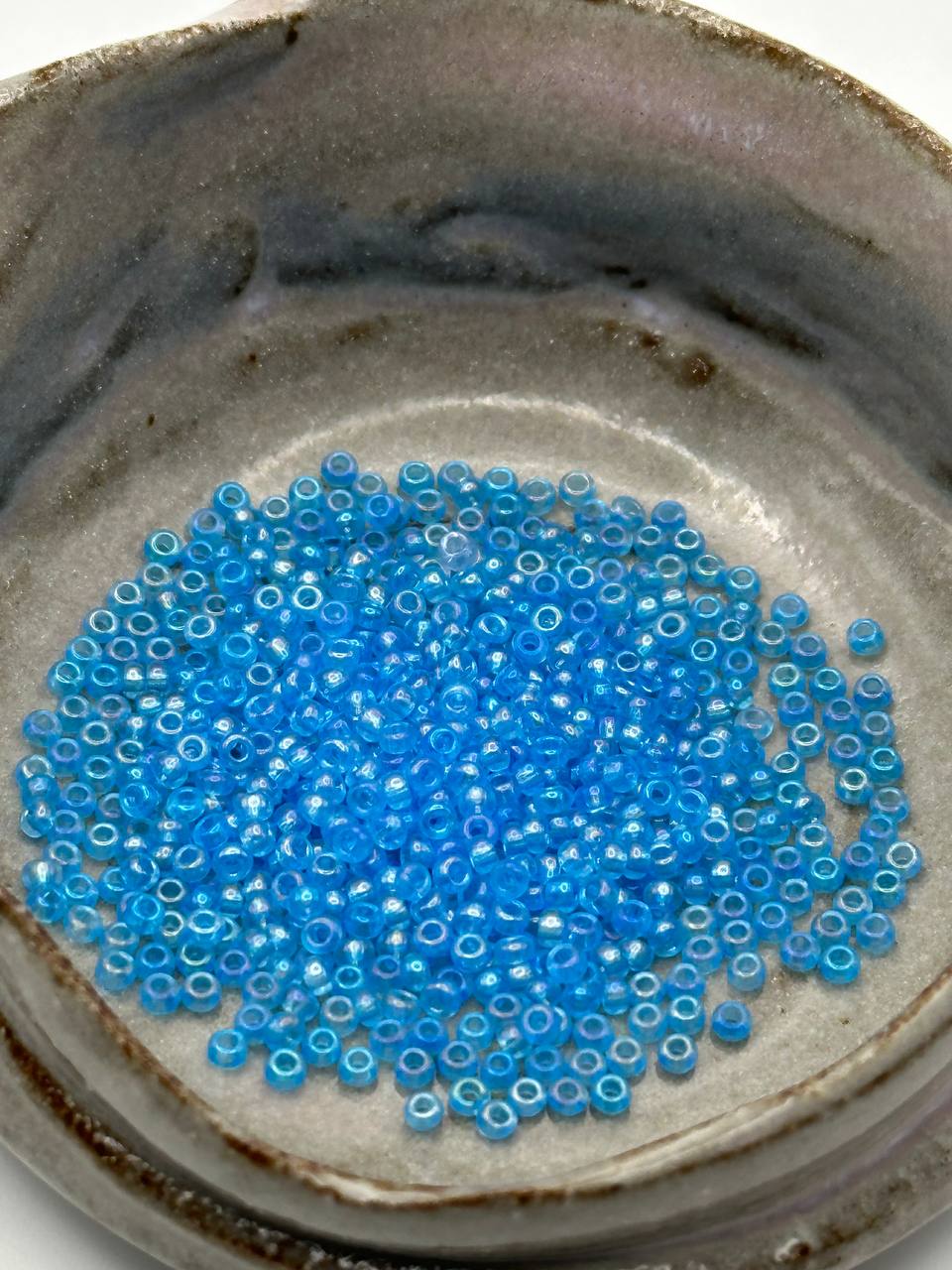 Blue beads on a textured ceramic surface