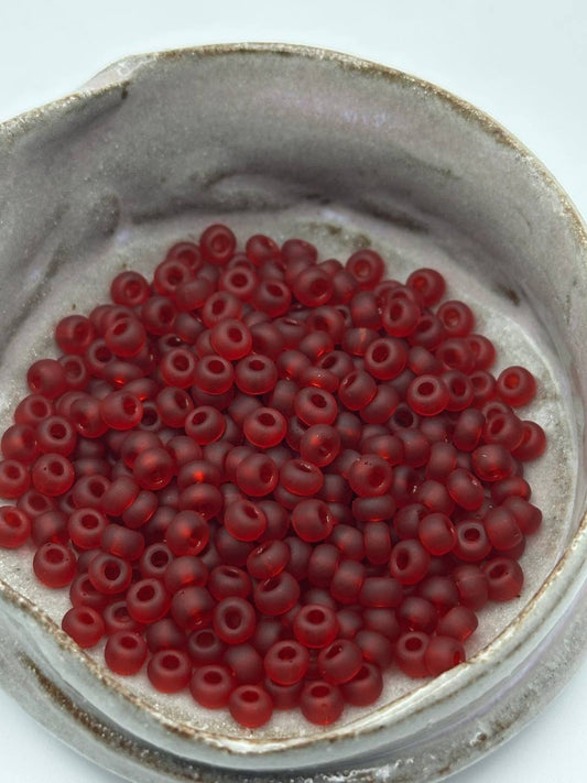 Red beads in a small container on a white background