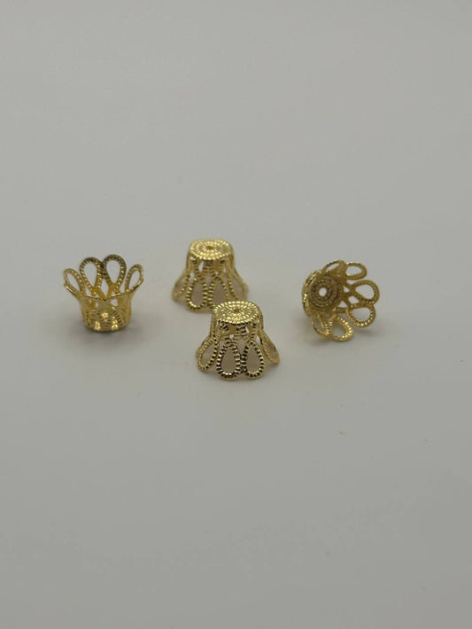 Four gold jewelry components on a gray background