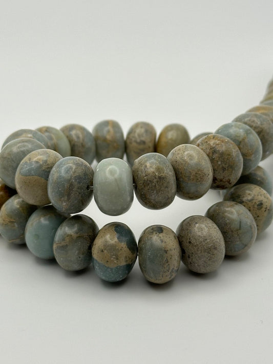 grey blue sandy picasso stone rondelle beads on white surface