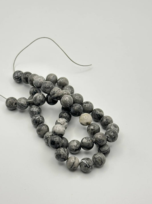 Black, white and grey round beads on a white surface