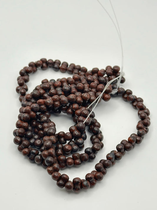 String of dark brown double beads on a white background