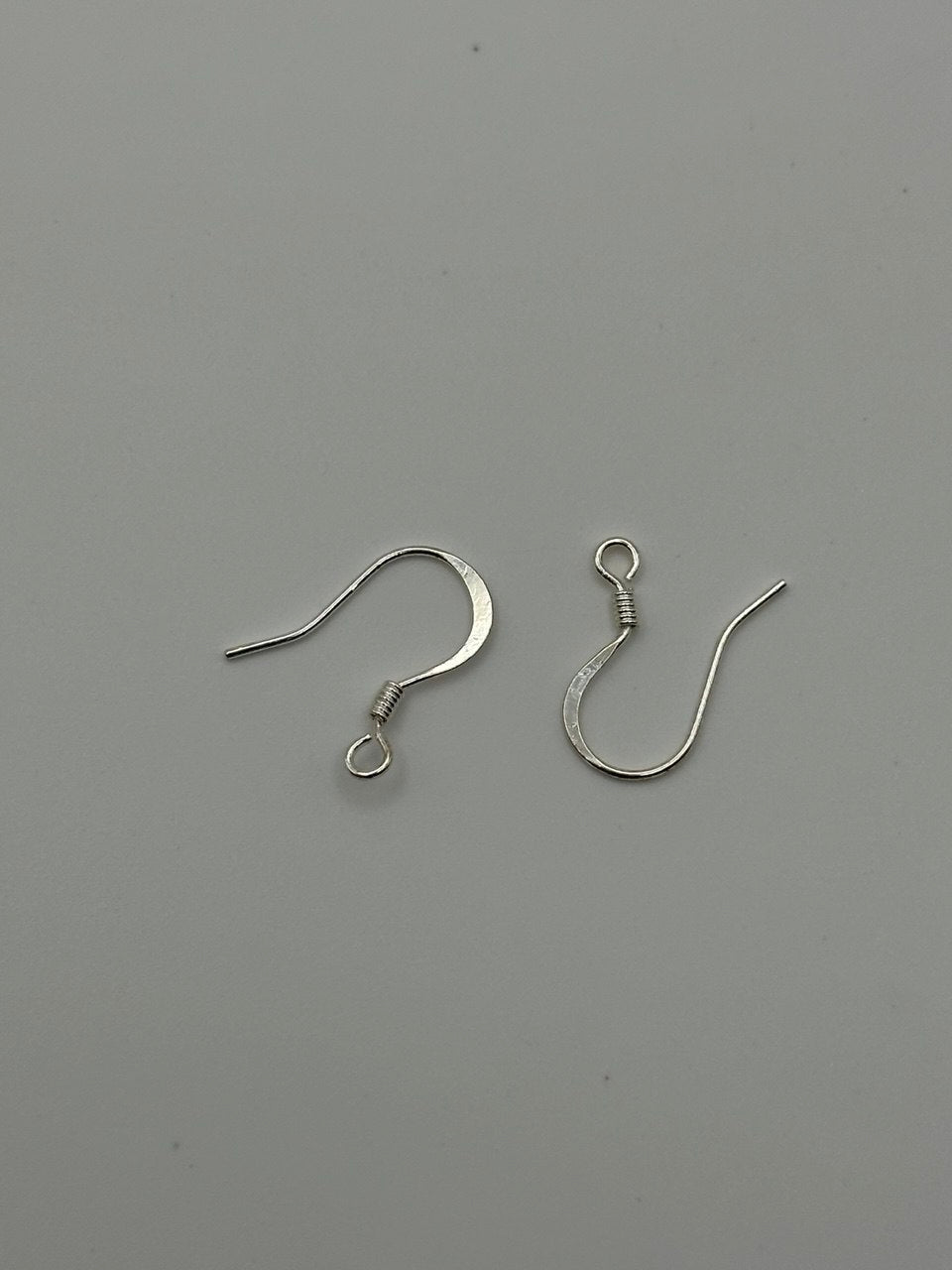 Silver plated ear wires on grey surface