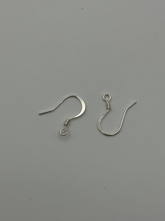 Silver plated ear wires on grey surface