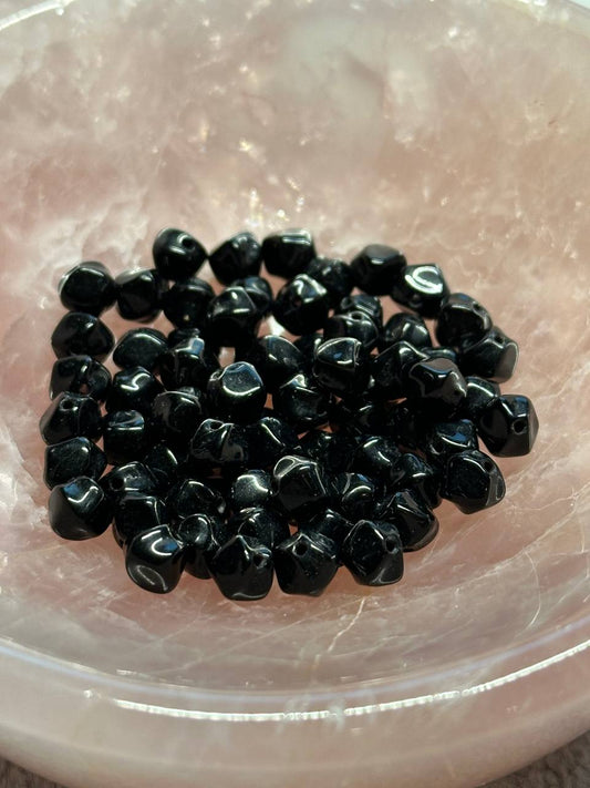 Black agate beads on a clear glass plate