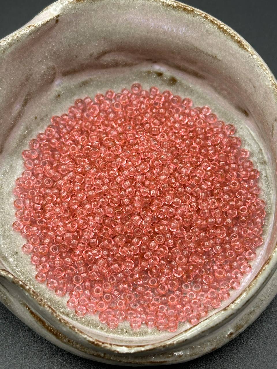 Rose pink seed beads in a grey container