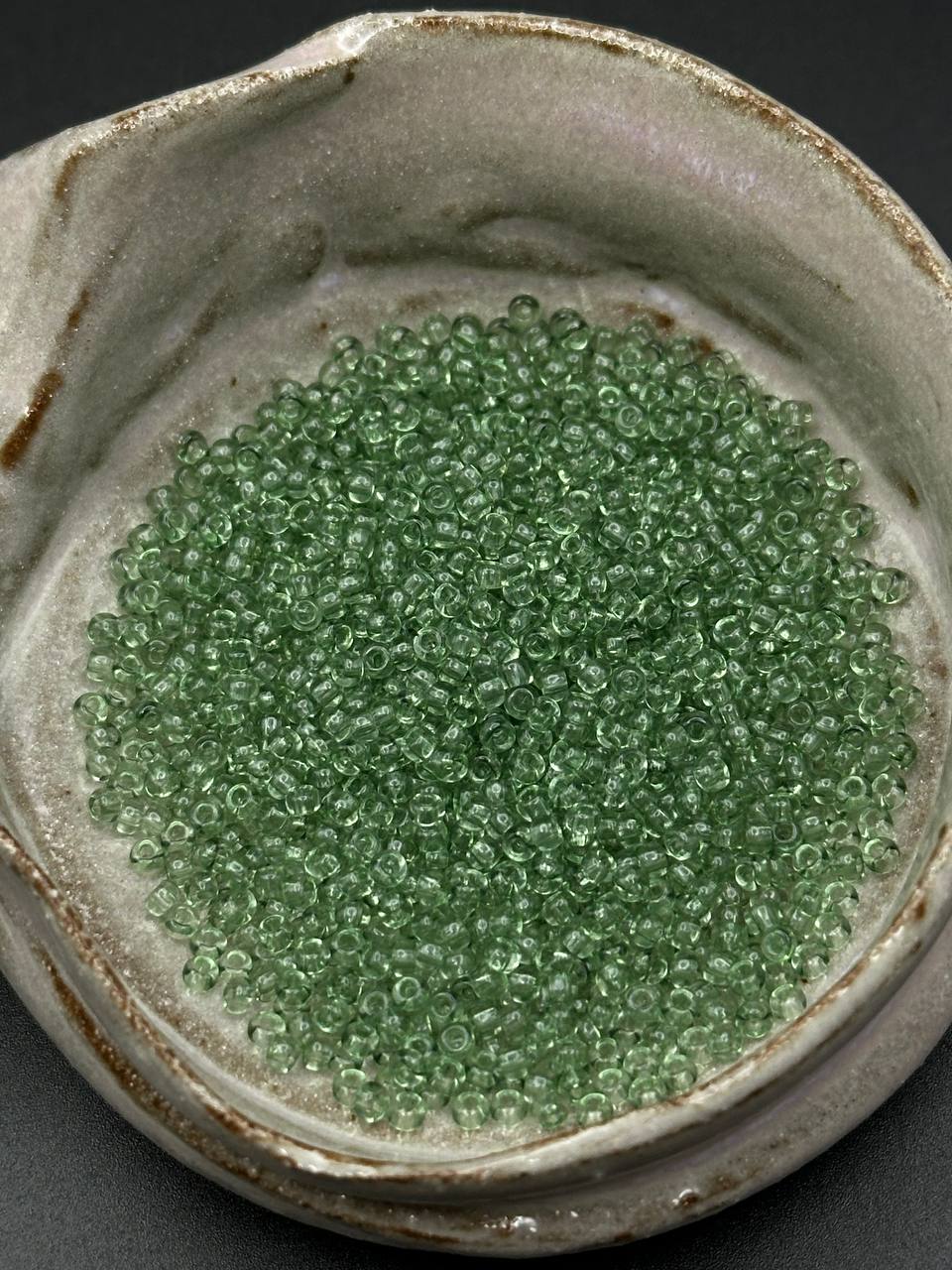 Mint green seed bead in a grey container