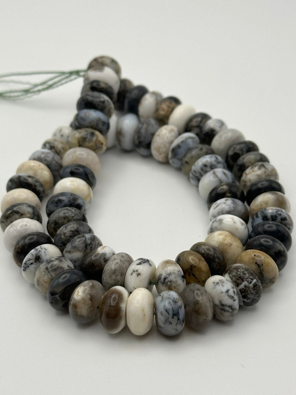 Multicolored dendritic agate beads on white surface