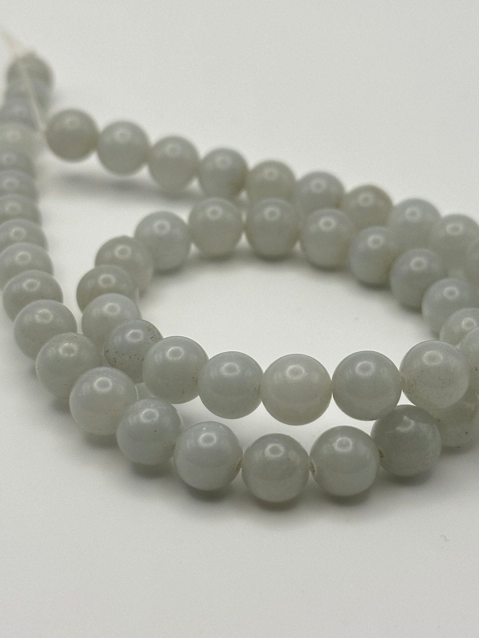 String of white lustrous beads on a white background