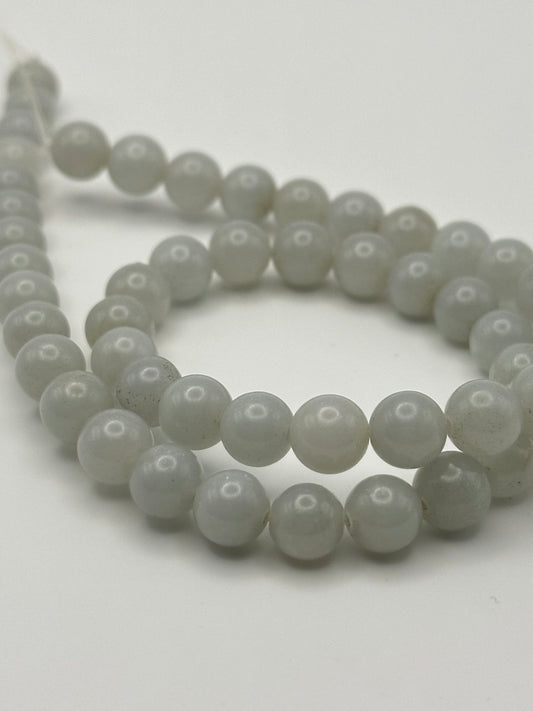 String of white lustrous beads on a white background