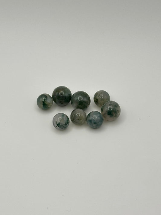 Set of multicolor green beads on a white background