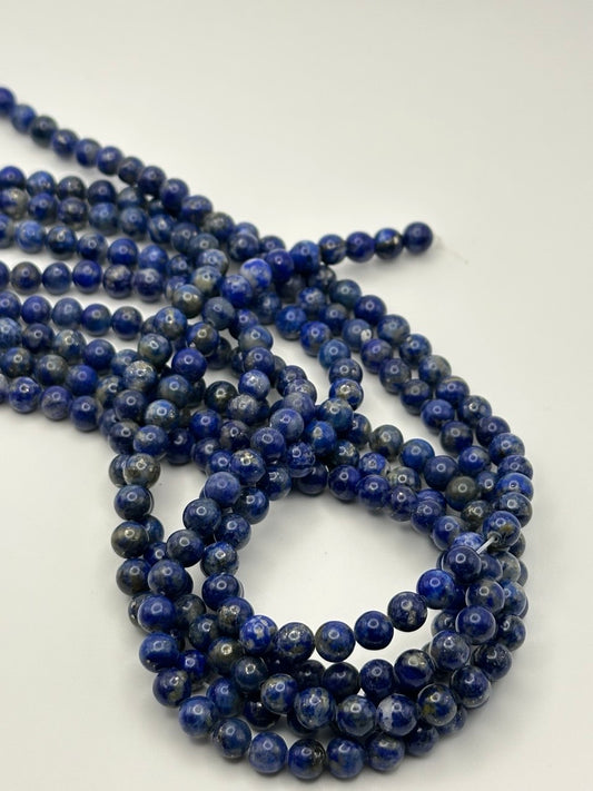 String of blue lapis lazuli beads on a white background