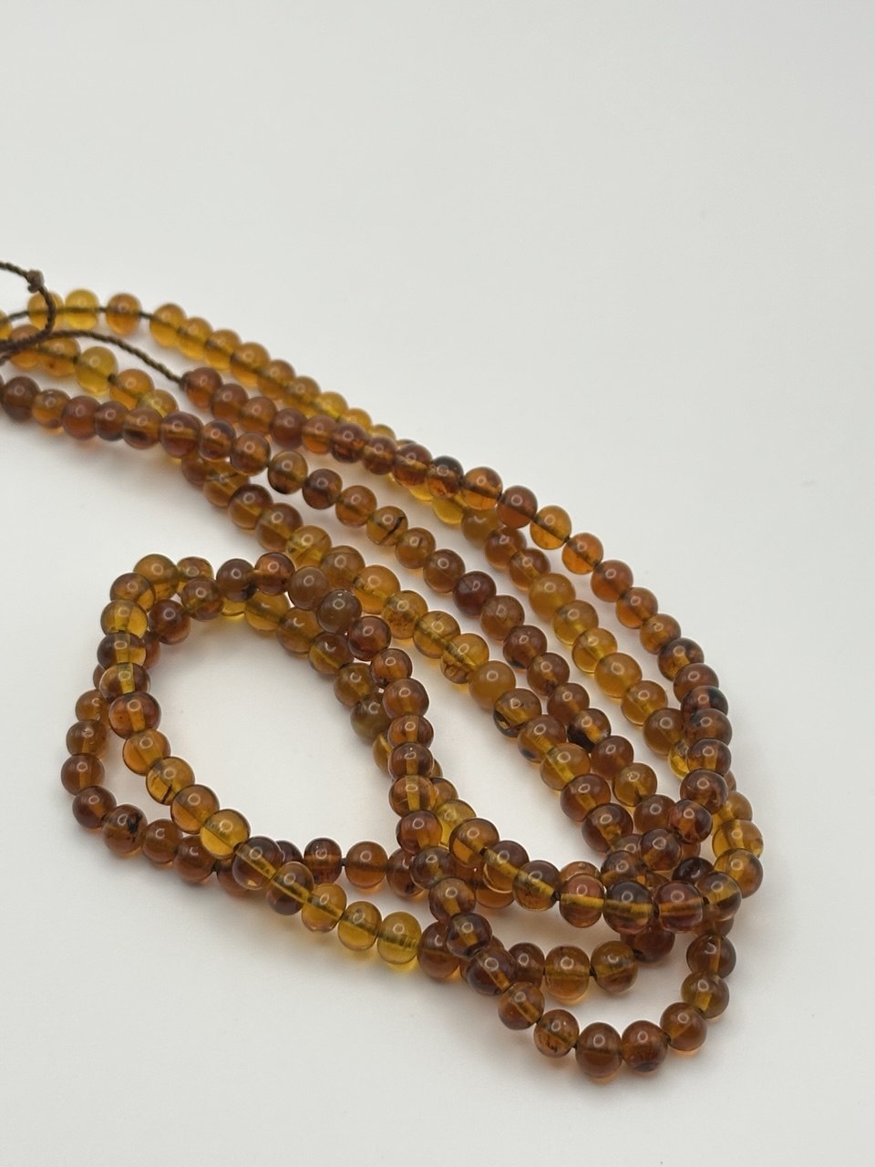 String of amber beads on a white background