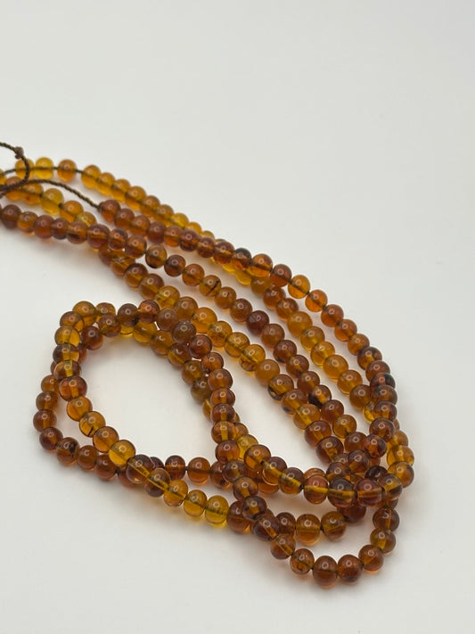 String of amber beads on a white background