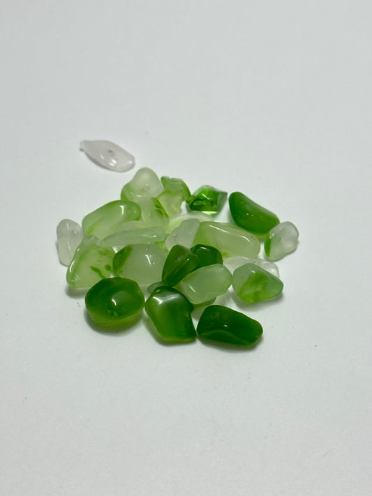 A small pile of grossular garnet chip beads on white background