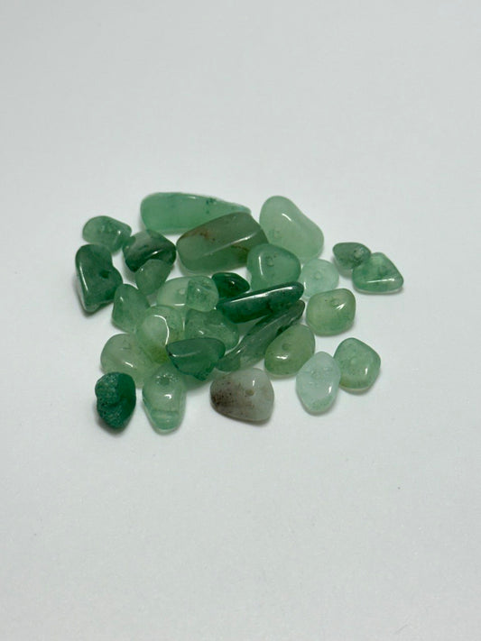 A small pile of aventurine chip beads on white background