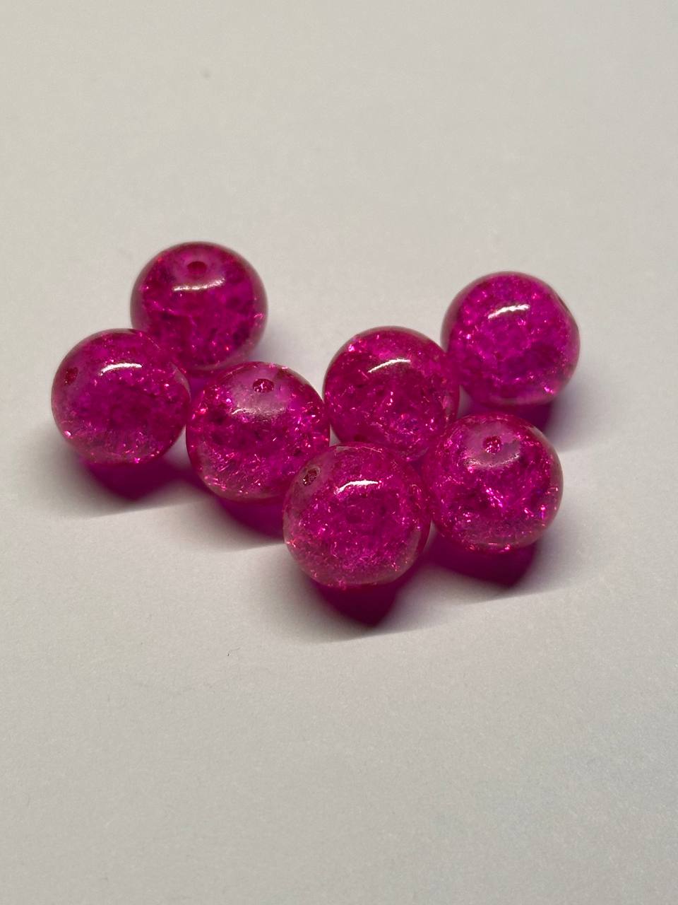 Pink glittery beads on a white background