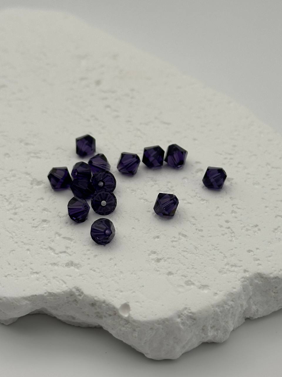 Purple velvet beads on a textured white surface