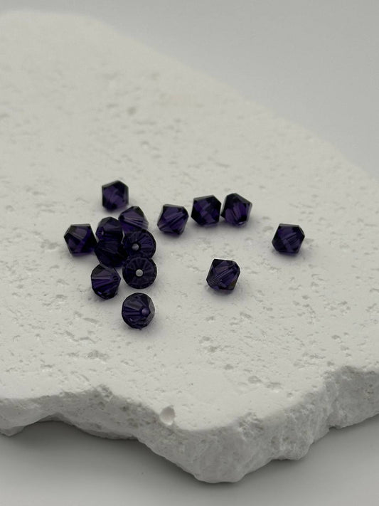 Purple velvet beads on a textured white surface