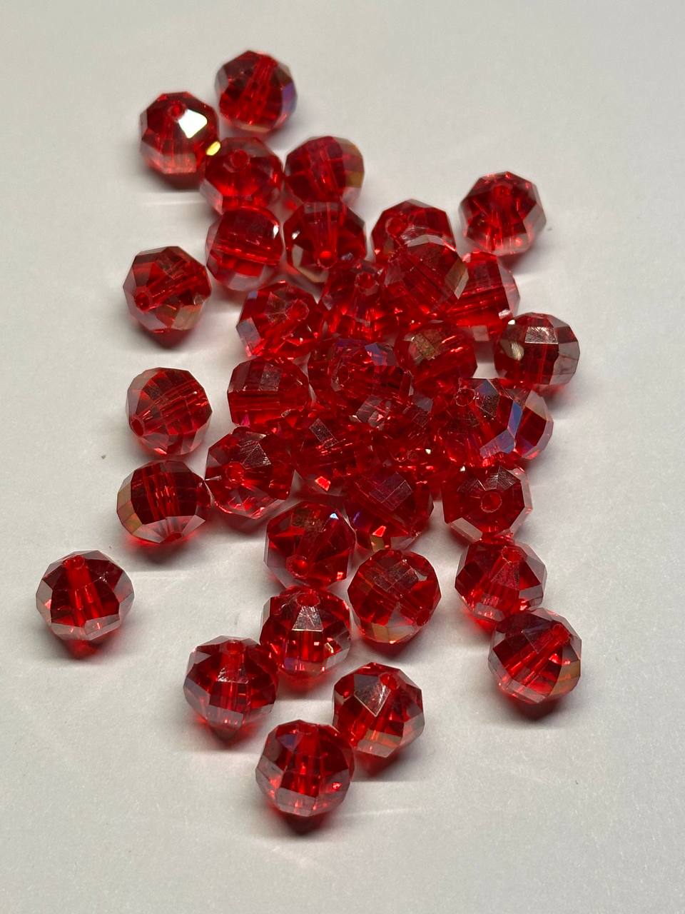 Red faceted beads on a light gray background