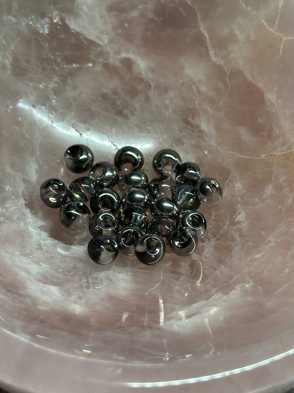 Metallic drop beads on a marble surface