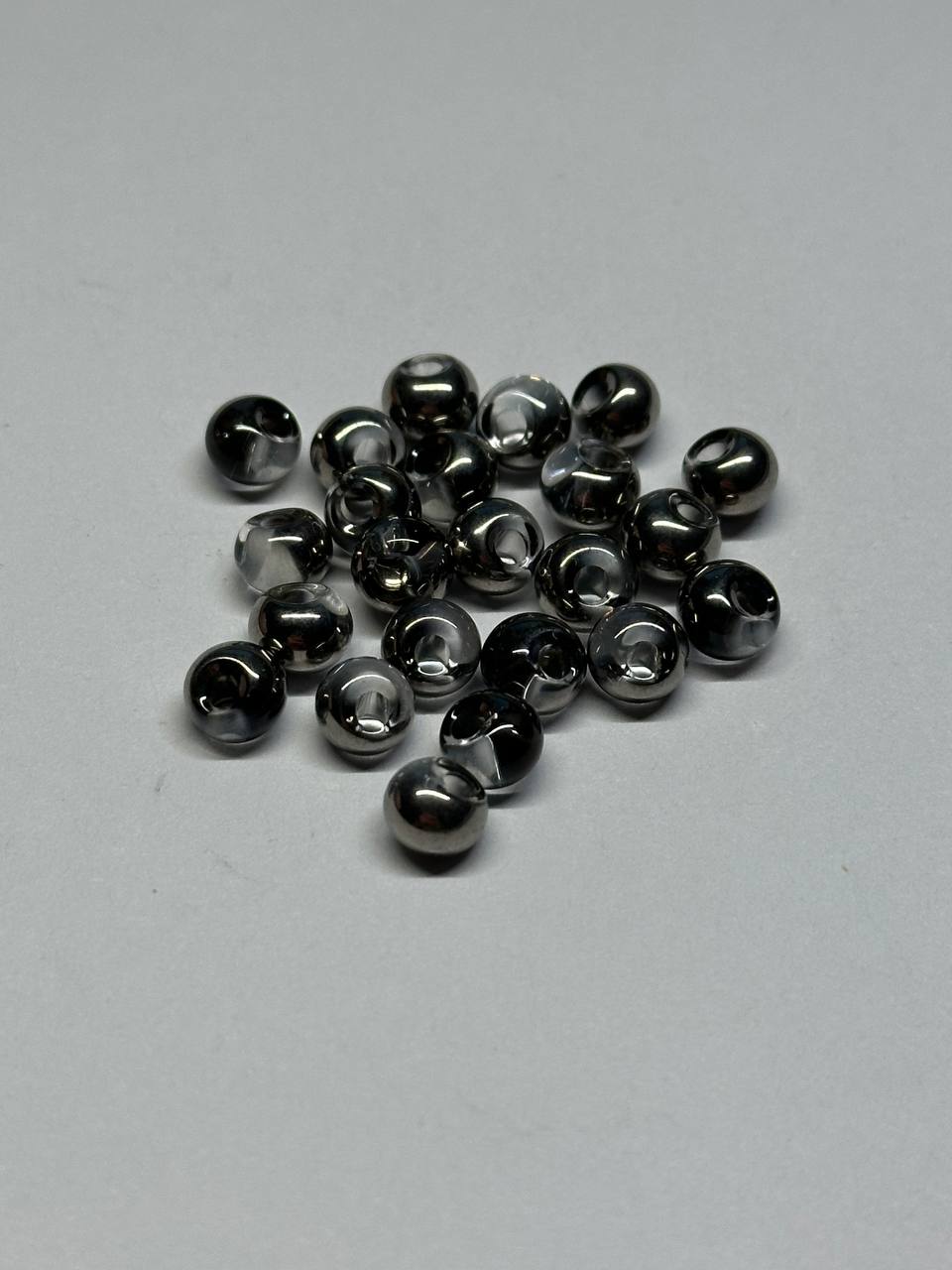 Collection of small metallic beads on a gray background