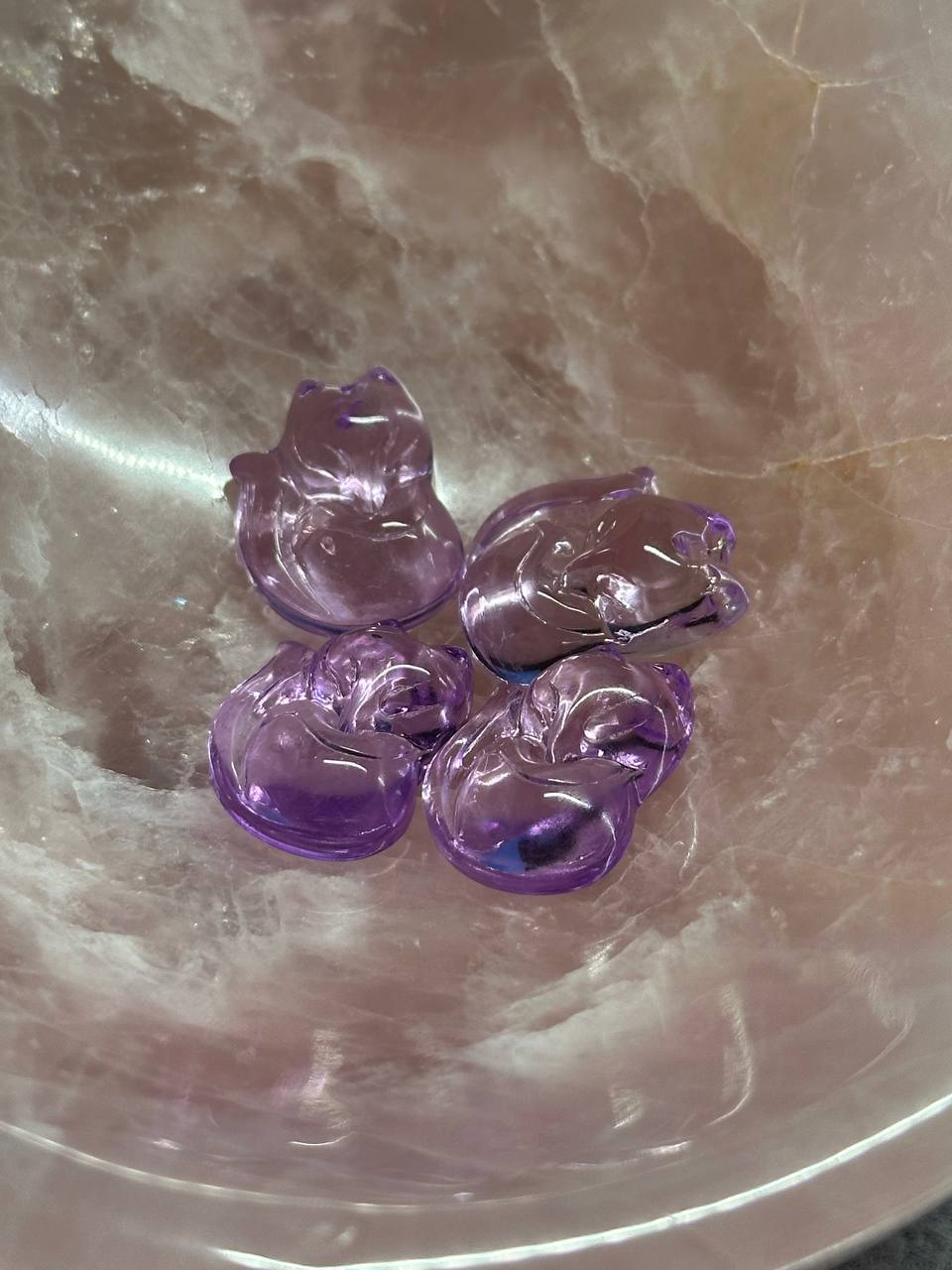 Purple glass beads on a textured surface