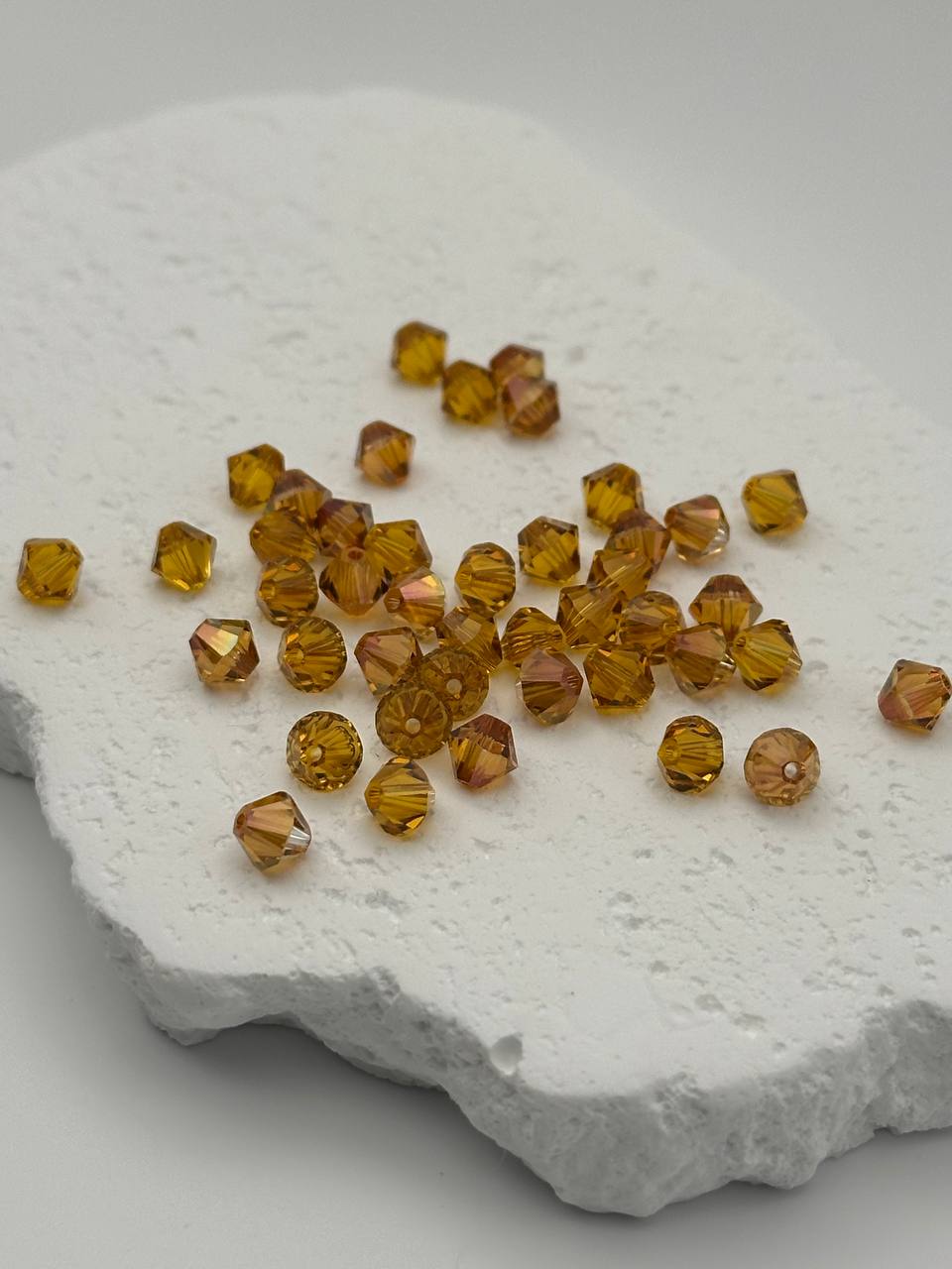 Amber-colored beads on a textured white surface