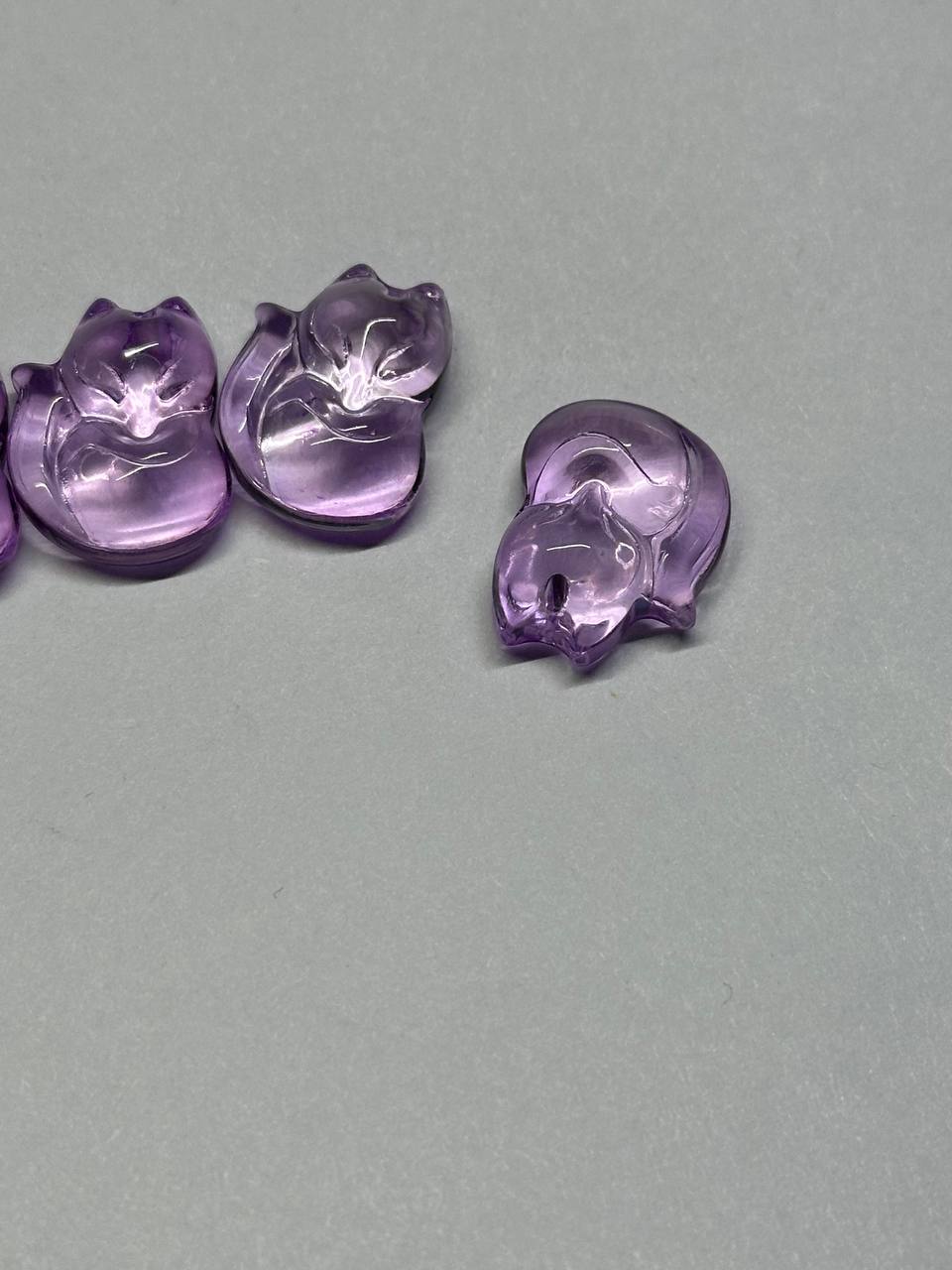 Purple fox-shaped beads on a gray background