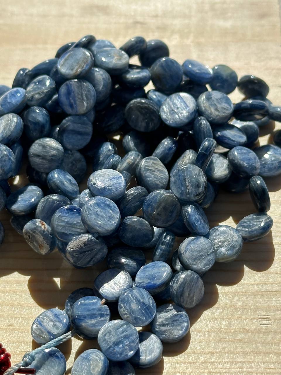 Blue kyanite beads on a wooden surface