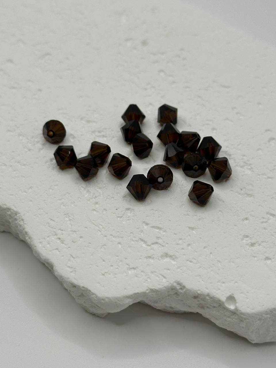 Dark brown beads on a textured white surface