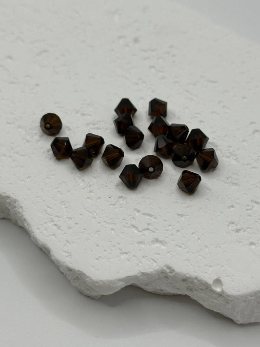Dark brown beads on a textured white surface