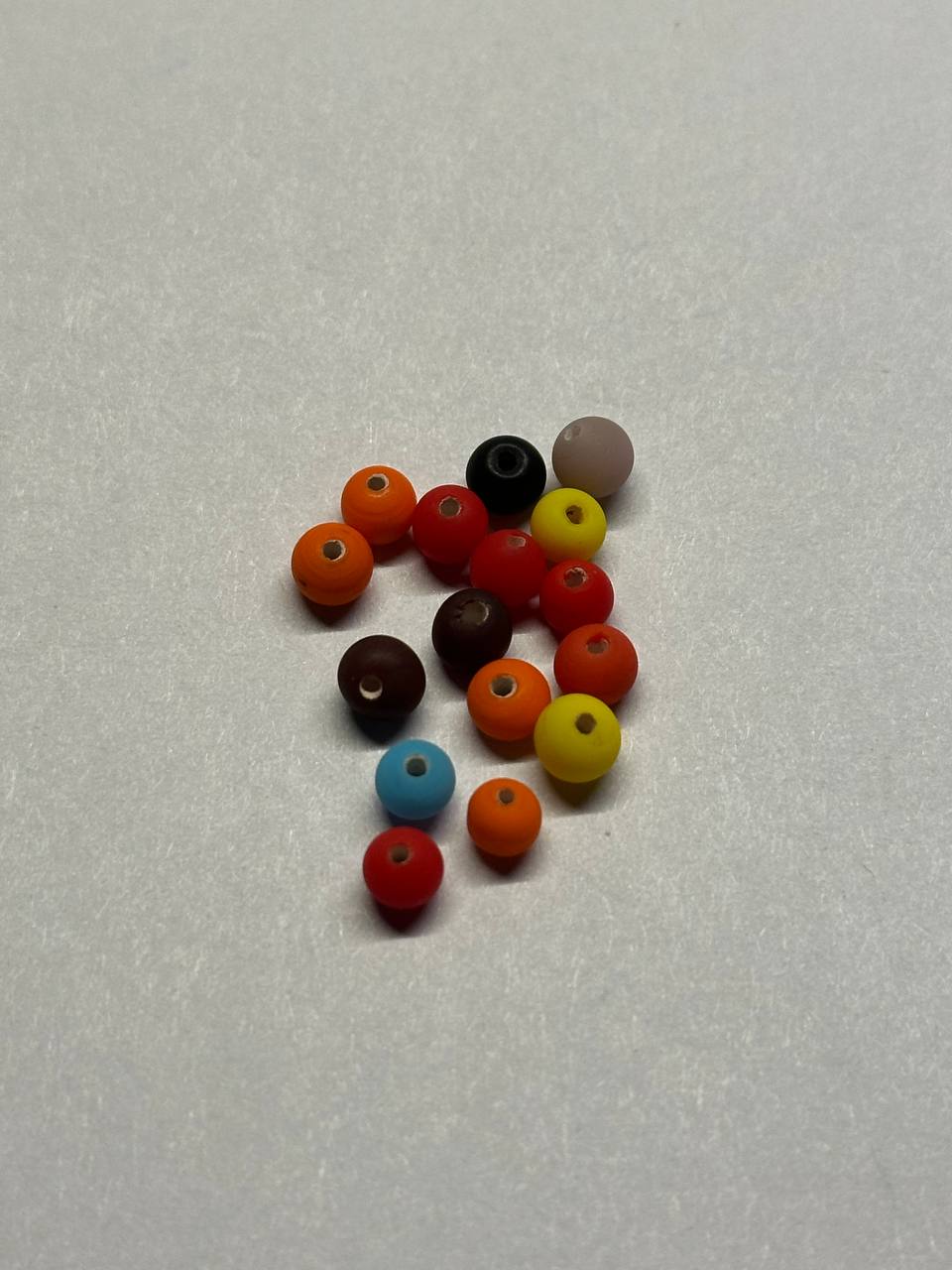 Assorted colored beads on a light gray background