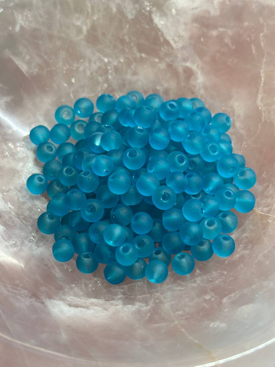 Turquoise beads on a reflective surface