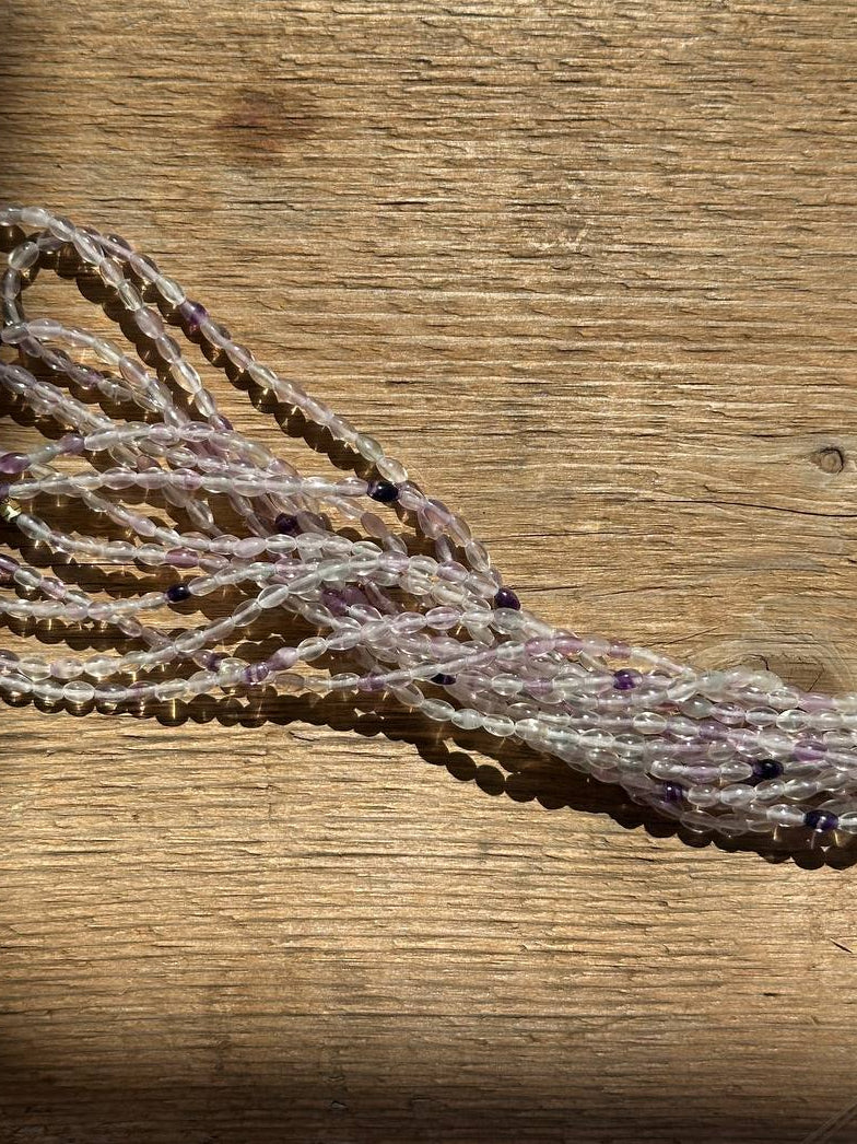 String of amethyst beads on a wooden surface