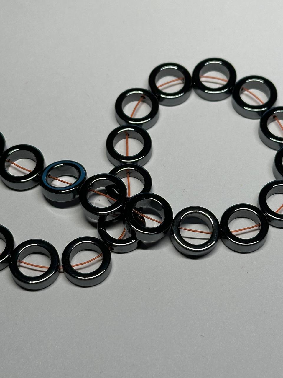 black hematite donut beads on grey surface