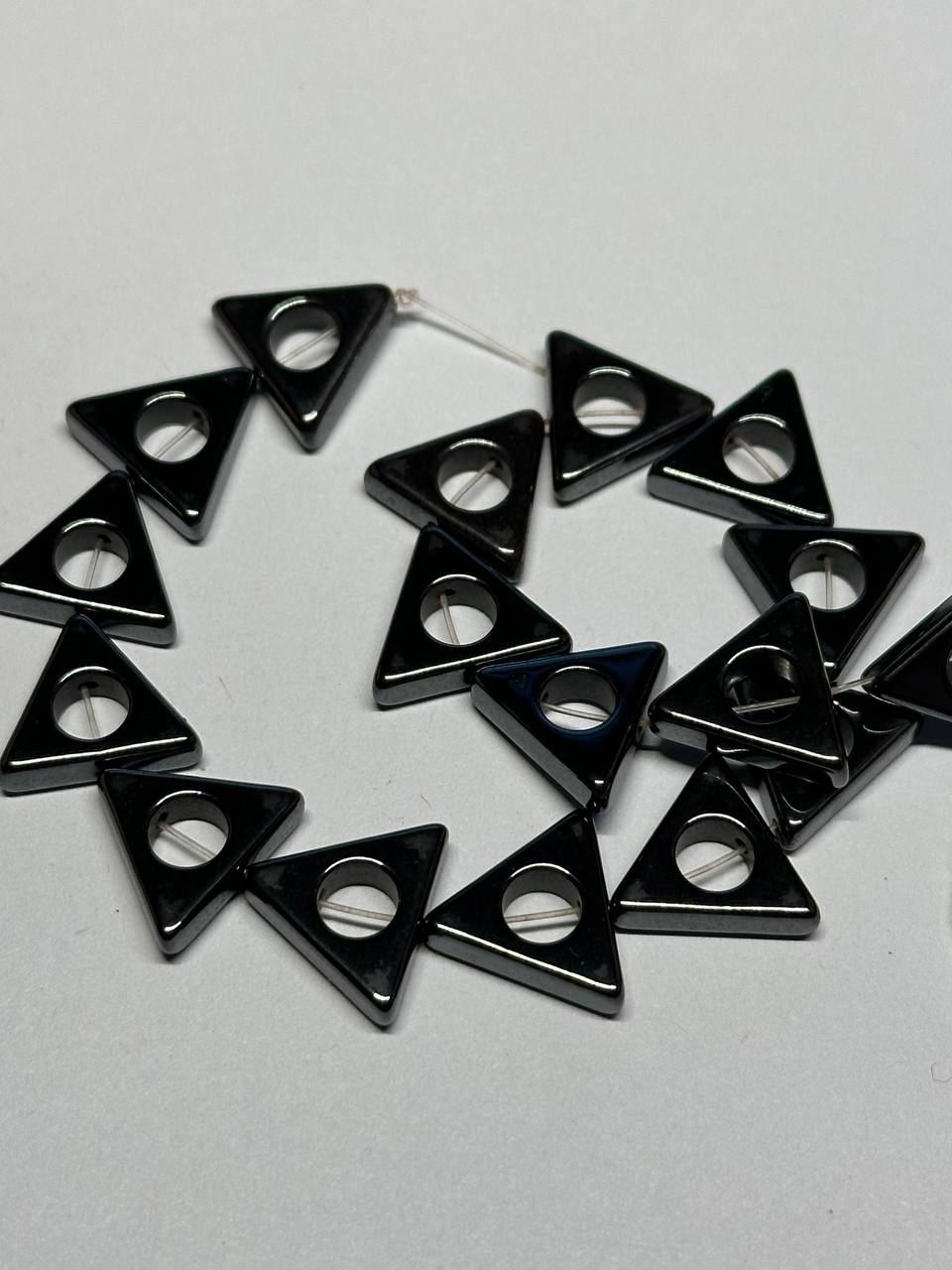 Black triangular hemalyke beads on a white background